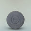 A round puck of Beardbrand Utility Bar against a grey background.