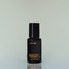 A bottle of Ghost Tracer Eau de Parfum against a grey background.