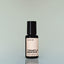 A bottle of Temple Smoke Eau de Parfum against a grey background.