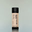 An Old Money Mustache Wax in a black plastic tube against a grey background.