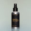 A bottle of Bold Fortune Utility Deodorant with a spray dispenser against a grey background.