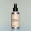 A bottle of Temple Smoke Utility Deodorant with a spray dispenser against a grey background.