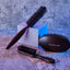 Three Beardbrand grooming brushes in different styles arranged on a textured surface with blue lighting.