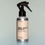 A bottle of Old Money Sea Salt Spray with a sprayer dispenser against a grey background.